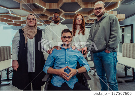 Young businessmen in a modern office extend a handshake to their business colleague in a wheelchair, showcasing inclusivity, support, and unity in the corporate environment. Young businessmen in a modern office extend a handshake to their business colleague in a wheelchair, showcasing inclusivity, support, and unity in the corporate environment. 127567600