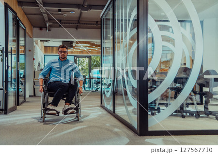 In a large modern corporation, a determined businessman in a wheelchair navigates through a hallway, embodying empowerment and inclusivity in the corporate world. 127567710