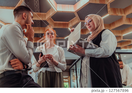 Young group of business people brainstorming together in a startup space, discussing business projects, investments, and solving challenges. 127567896