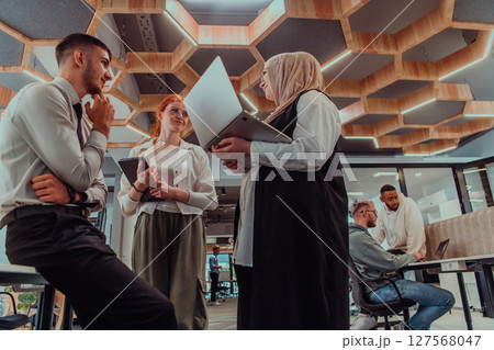 Young group of business people brainstorming together in a startup space, discussing business projects, investments, and solving challenges. Young group of business people brainstorming together in a startup space, discussing business projects, investments, and solving challenges. 127568047