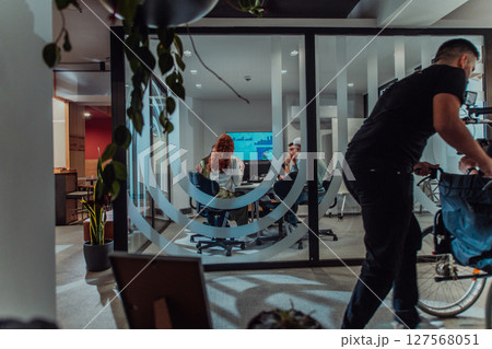 In a modern office, a professional team of videographers captures the essence of creativity and innovation as they film a group of young entrepreneurs, symbolizing collaboration and ambition in the 127568051