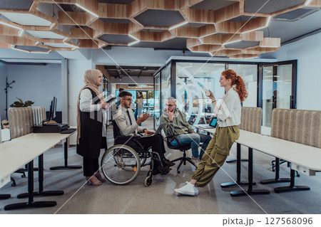 Young group of business people brainstorming together in a startup space, discussing business projects, investments, and solving challenges. 127568096