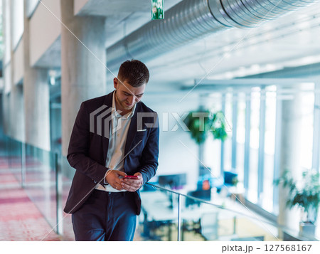 In a sleek corporate setting, the young and charismatic director strides confidently down the hallway, symbolizing his dynamic leadership and the promise of continued success within the company he 127568167