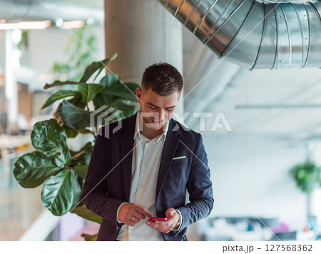 In a sleek corporate setting, the young and charismatic director strides confidently down the hallway, symbolizing his dynamic leadership and the promise of continued success within the company he 127568362