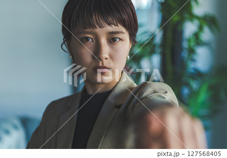 指す女性 127568405