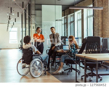 A diverse group of young business individuals congregates in a modern startup coworking center, embodying collaborative innovation and a dynamic atmosphere 127568452