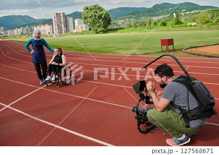 A cameraman filming the participants of the Paralympic race on the marathon course A cameraman filming the participants of the Paralympic race on the marathon course 127568671