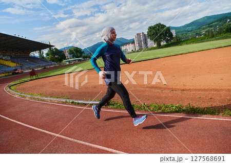 A muslim woman in a burqa sports muslim clothes running on a marathon course and preparing for upcoming competitions 127568691