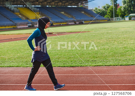 A Muslim woman with a burqa, an Islamic sportswoman resting after a vigorous training session on the marathon course. A hijab woman is preparing for a marathon competition 127568706