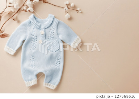 Baby knitted onesie on beige background. Fashion newborn clothes. Flat lay top view. Wool kid soft clothing. Infant trendy bodysuit made of organic eco friendly cotton. Children wardrobe. Baby garment 127569616