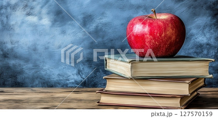 Red Apple on Stack of Vintage Books Education Knowledge old life blue study table still image photo 127570159