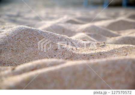 Close up of clean yellow sand surface covering seaside beach illuminated with day light. Travel and vacations concept Close up of clean yellow sand surface covering seaside beach illuminated with day light. Travel and vacations concept 127570572