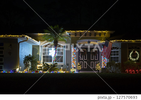Brightly illuminated christmas decorations on front yard of florida family home. Outside decor for winter holidays Brightly illuminated christmas decorations on front yard of florida family home. Outside decor for winter holidays 127570693