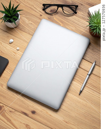 Silver Laptop on Wooden Desk with Plants and Glasses 127570936