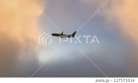 Airplane in the sky. Airplane in flight at sunset or evening sky. Commercial airliner silhouette in the colorful evening or night moon skies. Aircraft symbol of travel adventure global connectivity. Airplane in the sky. Airplane in flight at sunset or evening sky. Commercial airliner silhouette in the colorful evening or night moon skies. Aircraft symbol of travel adventure global connectivity. 127571014
