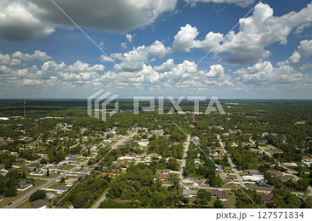 Aerial view of small town America suburban landscape with private homes between green palm trees in Florida quiet residential area Aerial view of small town America suburban landscape with private homes between green palm trees in Florida quiet residential area 127571834