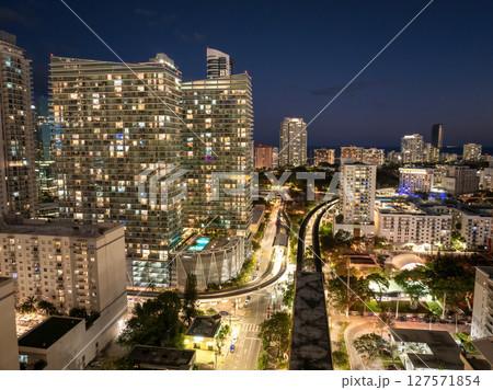 Aerial view of public train tracks running through the modern downtown of Miami, Florida, USA. High-rise buildings over railroad at night Aerial view of public train tracks running through the modern downtown of Miami, Florida, USA. High-rise buildings over railroad at night 127571854