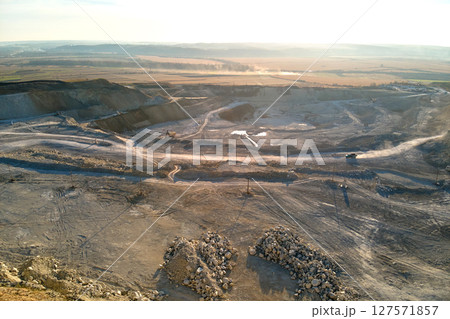Aerial view of open pit mining site of limestone materials for construction industry with excavators and dump trucks 127571857