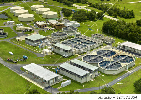 Aerial view of modern water cleaning facility at urban wastewater treatment plant. Purification process of removing undesirable chemicals, suspended solids and gases from contaminated liquid Aerial view of modern water cleaning facility at urban wastewater treatment plant. Purification process of removing undesirable chemicals, suspended solids and gases from contaminated liquid 127571864