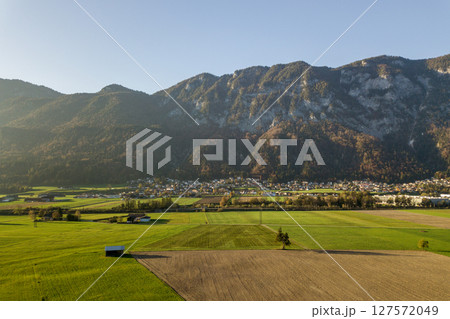 Aerial view of green meadows with villages and forest in austrian Alps mountains. Aerial view of green meadows with villages and forest in austrian Alps mountains. 127572049