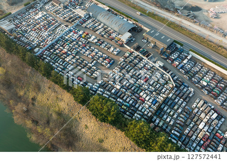 Aerial view of big parking lot of junkyard with rows of discarded broken cars. Recycling of old vehicles Aerial view of big parking lot of junkyard with rows of discarded broken cars. Recycling of old vehicles 127572441