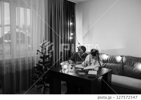 A grandparent and grandchild spend quality time together crafting during the holiday season. A grandparent and grandchild spend quality time together crafting during the holiday season. 127572547