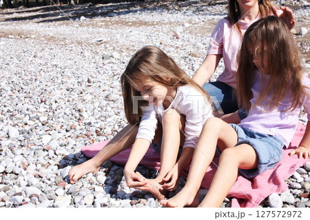 mother with twins daughters on beach mother with twins daughters on beach 127572972