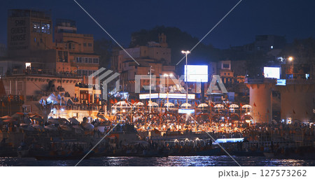 Varanasi, Uttar Pradesh, India. Evening Ganga Maha Aarti ceremony on Dashashwamedh Ghat. night time illumination lights. Cinematic Camera movement moving along riverbank embankment. View from 127573262