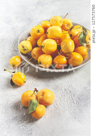 yellow small apples, Chinese variety, on a gray plate, top view, no people, 127573760