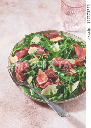 Fresh arugula salad with prosciutto and grated parmesan cheese, on a plate, homemade, no people, Fresh arugula salad with prosciutto and grated parmesan cheese, on a plate, homemade, no people, 127573776
