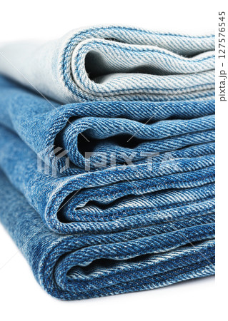 Pile of textiles in various shades of blue, stacked jeans fabric on top of each other in store 127576545