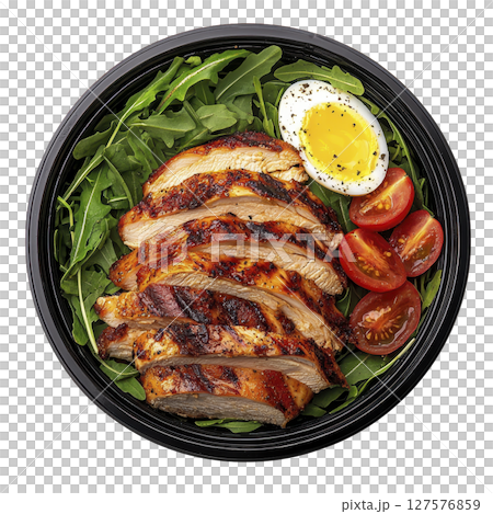 Grilled chicken salad with arugula, cherry tomatoes, and boiled egg on dark plate, seasoned with pepper. dish is vibrant and appetizing, perfect for healthy meal 127576859