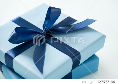 Two blue gift boxes for birthday on pastel blue background. Greeting card, flyer or invitation. Close up. Present for man. 127577130