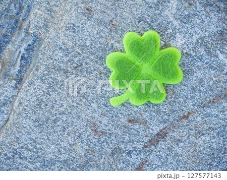 A green shamrock is on a gray rock A green shamrock is on a gray rock 127577143