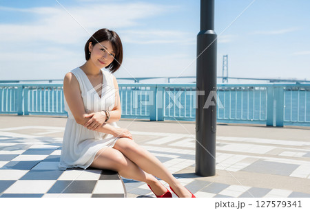 海岸の公園で座る女性 127579341