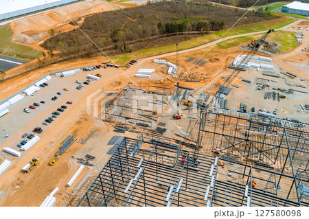 Large construction site with steel beams framework equipment shows progress on new facility suburban works 127580098