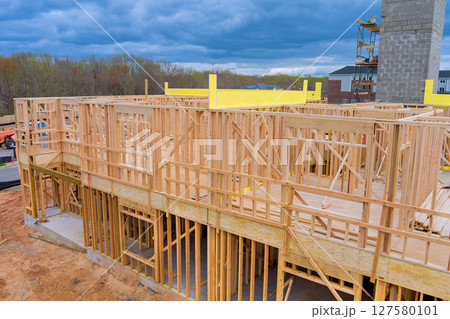 Workers build wooden beams framework for building under suburban location construction in developing area. Workers build wooden beams framework for building under suburban location construction in developing area. 127580101