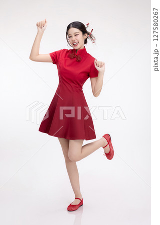 Full body portrait of joyful beauty Asian woman in red Cheongsam Chinese traditional dress celebrating and dancing isolated on white background. Full body portrait of joyful beauty Asian woman in red Cheongsam Chinese traditional dress celebrating and dancing isolated on white background. 127580267