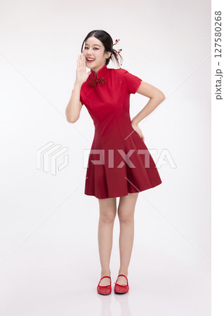 Full body portrait of joyful beauty Asian woman in red Cheongsam Chinese traditional dress celebrating and announcing isolated on white background. 127580268