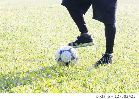 サッカーボールを蹴る男性の足元 127582423