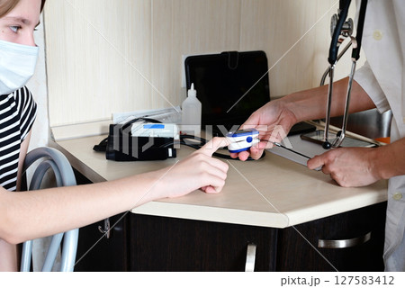 Health check in a medical office as a patient receives examination with a healthcare professional while using a medical device Health check in a medical office as a patient receives examination with a healthcare professional while using a medical device 127583412