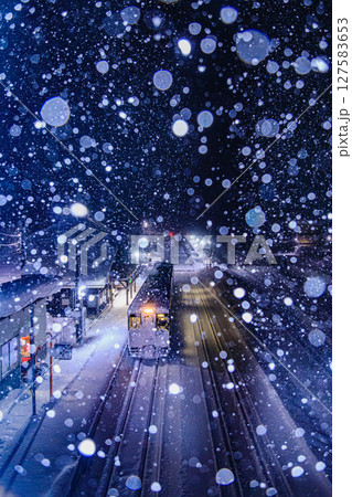 雪に包まれた夜のプラットホームと優しい光 127583653