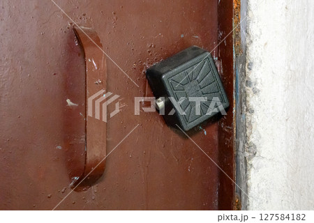 brown iron door with black padlock 127584182