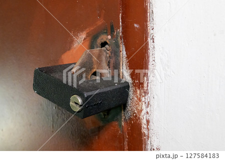 brown iron door with black padlock 127584183
