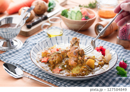 湯気立つ手作り手羽元カレーと彩り野菜の食卓 127584849