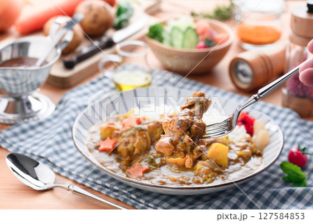湯気立つ手作り手羽元カレーと彩り野菜の食卓 127584853