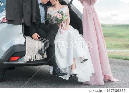 キスするカーウェディング・ブライダルカーのウェディングフォトを撮影をする新郎新婦・カップル 127586235