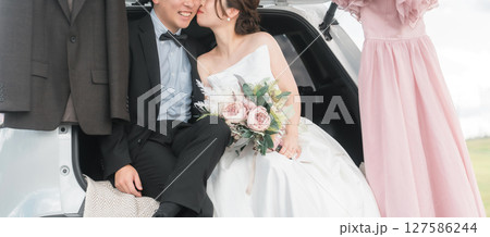 キスするカーウェディング・ブライダルカーのウェディングフォトを撮影をする新郎新婦・カップル 127586244