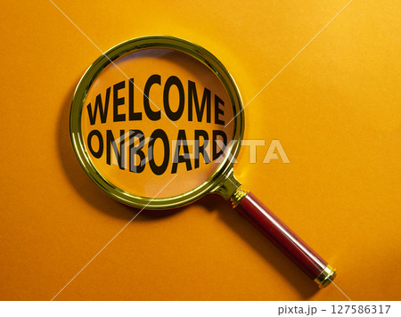 Welcome onboard symbol. Magnifying Glass with Concept word Welcome onboard. Beautiful orange background. Business and Welcome onboard concept. Copy space Welcome onboard symbol. Magnifying Glass with Concept word Welcome onboard. Beautiful orange background. Business and Welcome onboard concept. Copy space 127586317