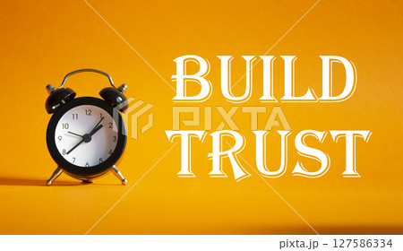 Build trust symbol. Beautiful orange background with alarm clock. Business and Build trust concept. Copy space. Build trust symbol. Beautiful orange background with alarm clock. Business and Build trust concept. Copy space. 127586334